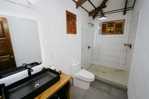 a bathroom with a white toilet and a sink at Dreamy Contentment in Matapalo