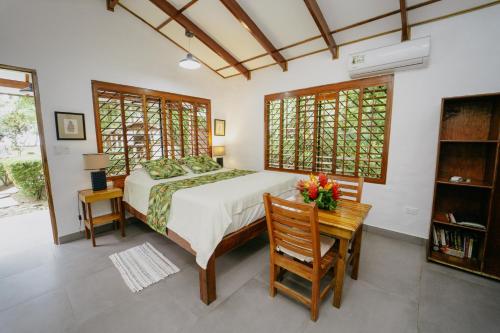 a bedroom with a bed and a table and chairs at Dreamy Contentment in Matapalo