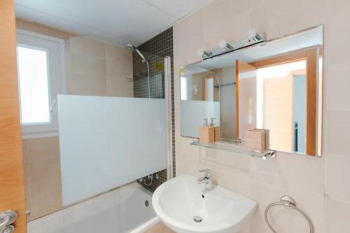 Un baño blanco con lavabo y espejo. en Villa Marejada 19, en San José