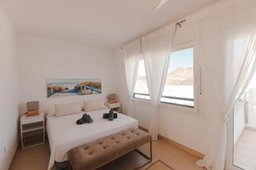 a white bedroom with a bed and a window at Villa Marejada 19 in San José
