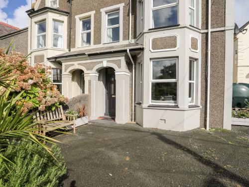 una casa con un banco delante de ella en Bodfan - Morfa Nefyn, en Pwllheli