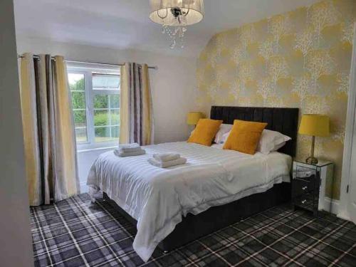 a bedroom with a large bed with yellow pillows at Holly Cottage Country Retreat in Wickenby