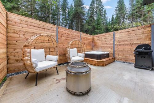 a patio with two chairs and a grill and a table at Les Petits Chalets in Val-des-Lacs