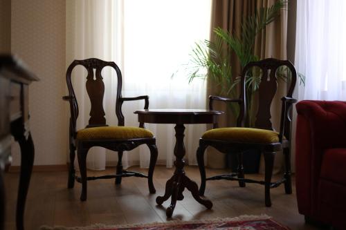 two chairs and a table in a room with a window at Mukhrantubani Boutique Hotel in Tbilisi City