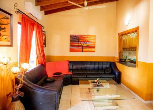 a living room with a leather couch and a table at Hermoso Depto en Calle Palma Asunción 290 m2 - Centro Histórico de Asunción in Asuncion