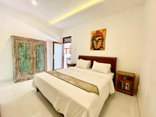 1 dormitorio con 1 cama y una foto en la pared en Timaya Villa, en Legian