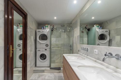 ein Badezimmer mit 2 Waschmaschinen und einem Waschbecken in der Unterkunft Unique first line apartment in Marbella