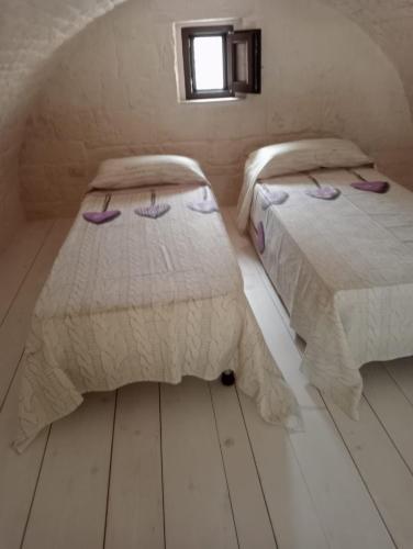 a bedroom with two beds and a window at A Due Passi dal Centro - Monte Grappa in Alberobello