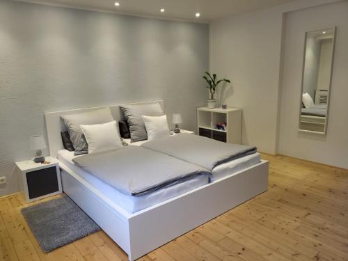 sypialnia z dużym białym łóżkiem w pokoju w obiekcie Tritt ein bring Glück herein - Exquisite 75 qm - Messenähe - Parkplatz - Flughafennähe w mieście Düsseldorf