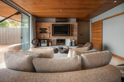 uma sala de estar com um sofá e uma televisão em Ponta dos Ganchos Exclusive Resort em Governador Celso Ramos