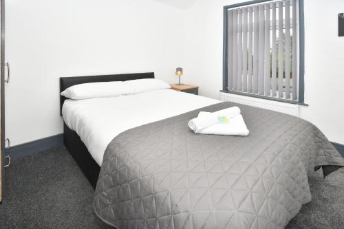 a bedroom with a bed with two towels on it at Townhouse @ Bedford Street Crewe in Crewe