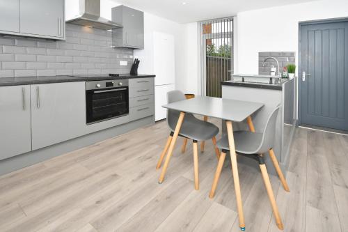 a kitchen with a table and chairs in a room at Townhouse @ Bedford Street Crewe in Crewe