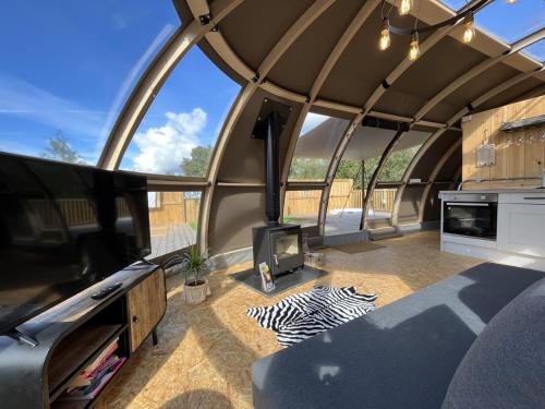 ein großes Zelt mit einem TV und einem Wohnzimmer in der Unterkunft Sunrise Dome Tent in Tenby