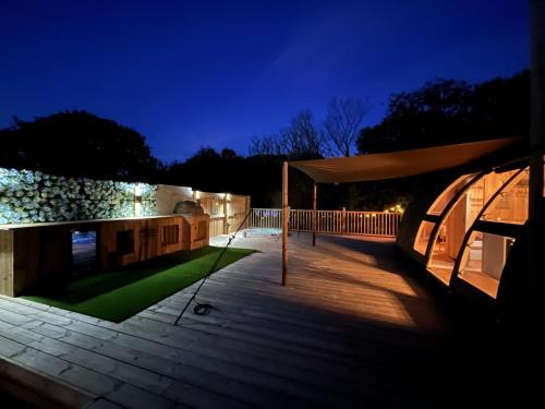 a deck with a gazebo at night at Sunrise Dome Tent in Tenby