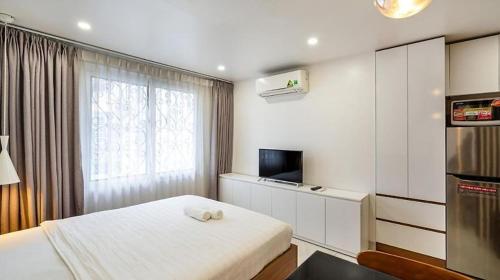 um quarto com uma cama, uma televisão e uma janela em HANZ Premium Hotel Sakura em Cidade de Ho Chi Minh