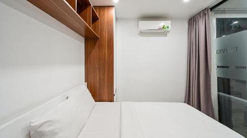um pequeno quarto com uma cama branca e uma janela em HANZ Premium Hotel Sakura em Cidade de Ho Chi Minh