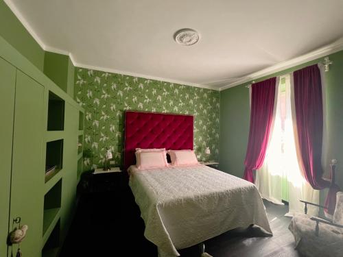 a bedroom with a bed with a red headboard at Casa Fara in Fara San Martino