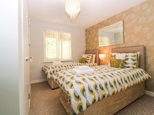 a bedroom with two beds and a mirror at 17 Valley Lodges in Callington