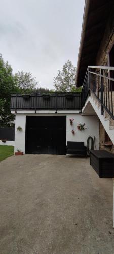 un garaje con una puerta negra y una escalera en Great place, rural environment, en Aránzazu Celaya