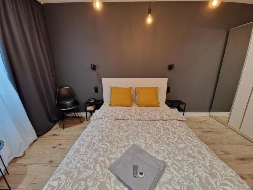 a bedroom with a large bed with two orange pillows at Tesorio Apartment - AC, Free Parking, WiFi, Business & Family in Wrocław