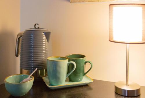 a table with three coffee cups and a lamp at Repetita Juvant in Rome