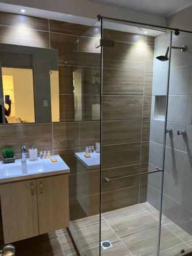 a bathroom with a glass shower and two sinks at LD House Flora in Cali