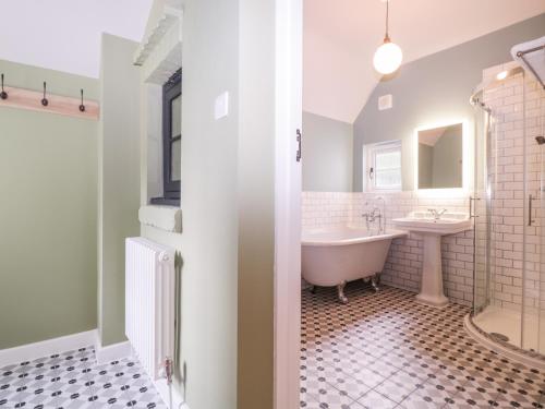 a bathroom with a tub and a sink at Barn Hoppitt Lodge in London