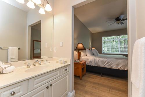 1 dormitorio con 1 cama y baño con lavabo. en Crown Isle Resort & Golf Community, en Courtenay