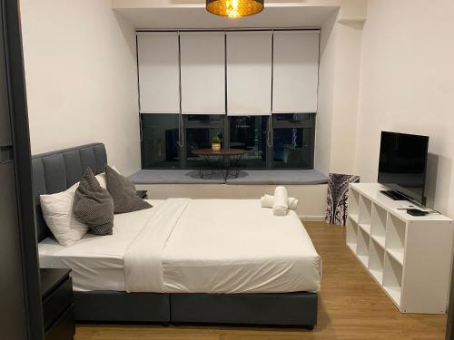 1 dormitorio con 1 cama grande y TV en Ceylonz Suite, en Kuala Lumpur