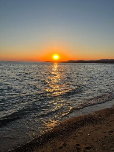a sunset on the beach with the sun setting at Paralia Homes peaceful 2 bedroom, unit # 2 in Kriopigi
