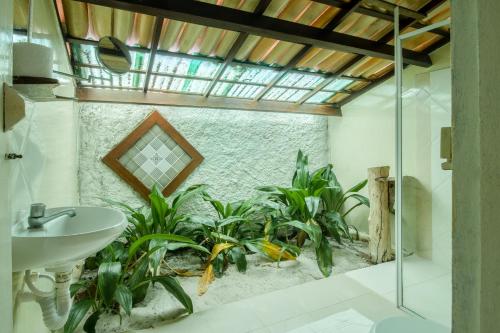 uma casa de banho com um lavatório e um monte de plantas em Pousada Marezia Top 5 na Linha Verde em Porto de Sauípe