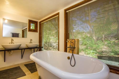 a bathroom with a tub and two sinks and a window at Garmen Hills Guest Houses in Garmen