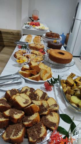 a table topped with plates of bread and desserts at Pousada Ponta da Baleia in Barra Grande