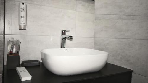 a bathroom with a white sink and a faucet at Hotel Callisto in Pristina