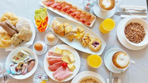 a table with plates of food and cups of coffee at Hotel Brenner - Stop & Go in Vipiteno