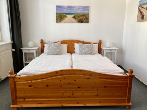 ein Schlafzimmer mit einem Holzbett mit zwei Nachttischen in der Unterkunft Ferienwohnung Windlicht in Kühlungsborn