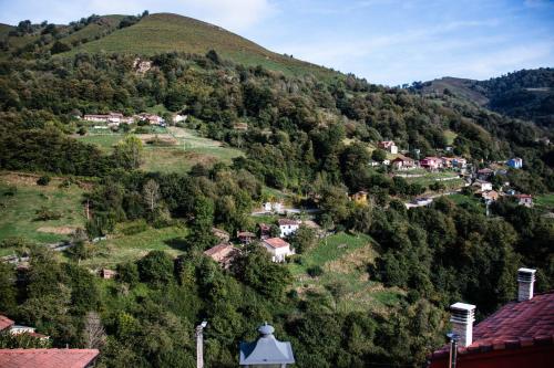un pequeño pueblo en una colina con casas en El Carbayu - La Vallicuerra Casas Rurales en Mieres