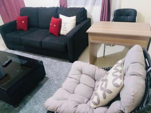 a living room with a couch and a table at Joshua’s place: cosy furnished one bedroom apt in Meru