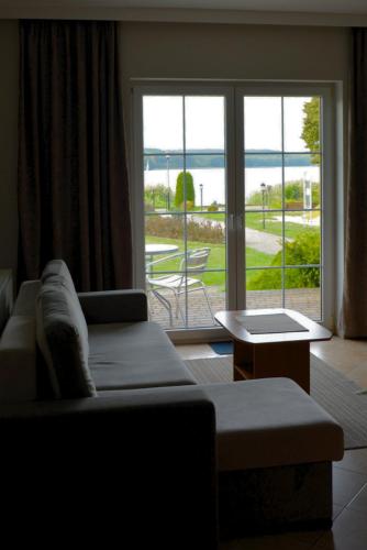 a living room with a couch and a large window at PARADISE Apartamenty in Charzykowy