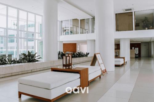 eine Lobby mit einem Sofa und Stühlen in einem Gebäude in der Unterkunft Qavi - Flat com Jacuzzi em Resort Beira Mar Cotovelo #InMare7 in Parnamirim