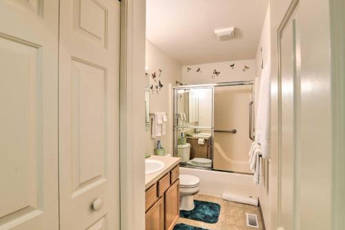 a white bathroom with a toilet and a sink at Quaint Ranch Home with Yard in Midtown Anchorage! in Anchorage