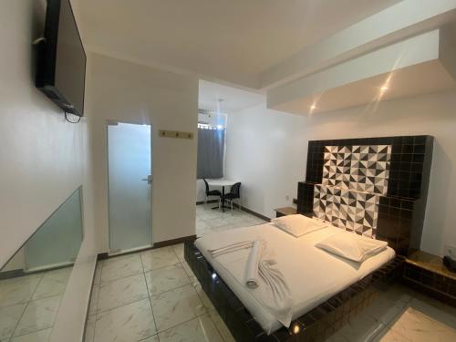1 dormitorio con 1 cama y TV en Hotel Bom Gosto, en Salvador