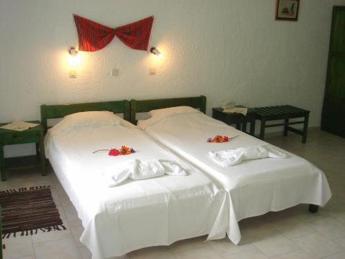 a bedroom with two beds with white sheets and red bows at Hotel Finiki View in Foinikion