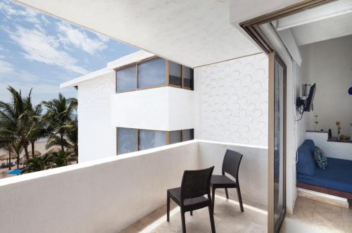a balcony with two chairs and a table at Hotel Villa Varadero in Nuevo Vallarta 