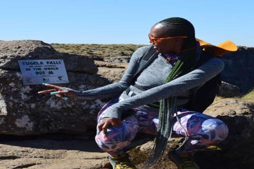 a woman sitting on a rock holding a sign at Maluti Backpackers in Phuthaditjhaba