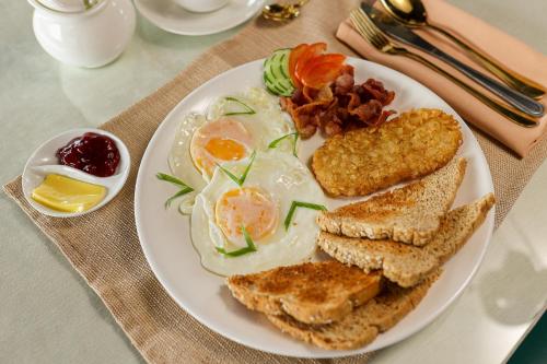 a white plate with eggs and toast and bacon at Kingswick Residences & Lodge in Dumaguete
