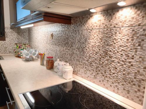 cocina con fregadero y pared de azulejos en Quiet spot Rock view House, en Kalambaka