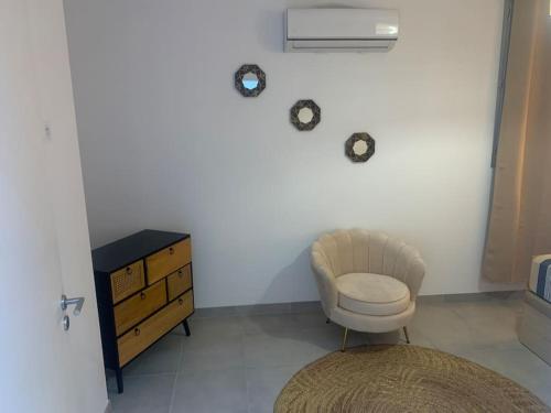 uma sala de estar com uma cadeira e uma cómoda em Sandspa logement avec jacuzzi em Orange