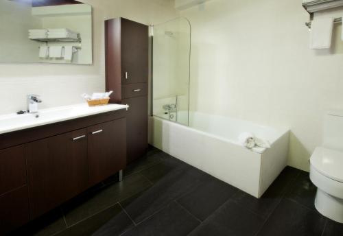 a bathroom with a tub and a sink and a toilet at Apartamentos Abad Toledo in Toledo