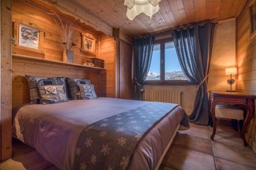 a bedroom in a log cabin with a bed and a window at Chalet Nessa in Combloux